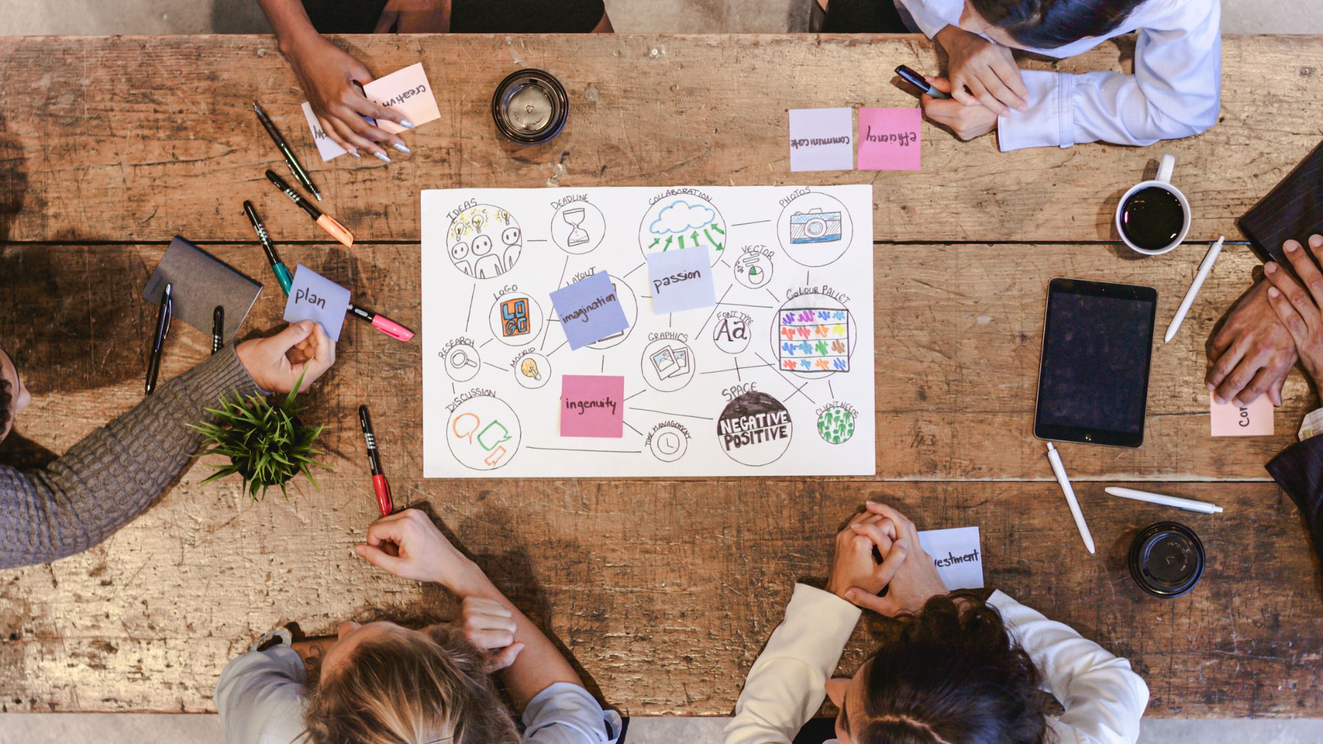 Creative team planning their digital marketing strategy, surrounded by pens and tablets as working tools.