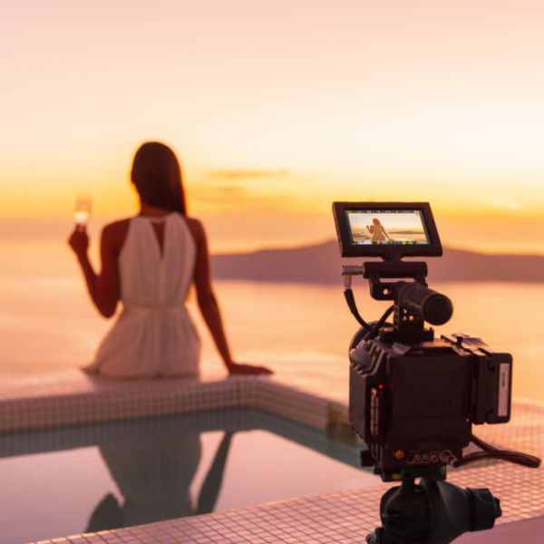 A female travel influencer posing for hotel video marketing content in the hotel's pool.