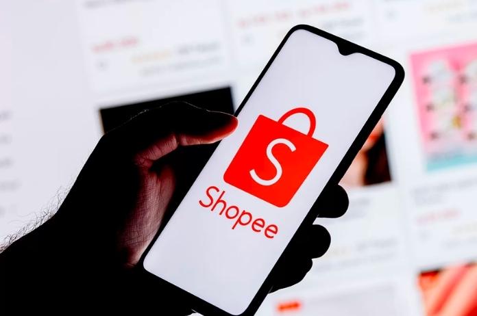 Hand of male digital marketer opening Shopee application on smartphone