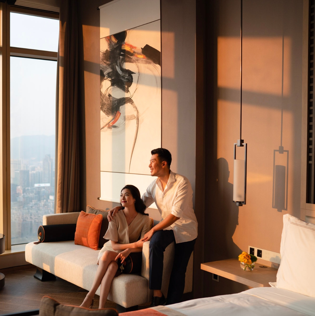 two couple look at the hotel's window from their luxury hotel room
