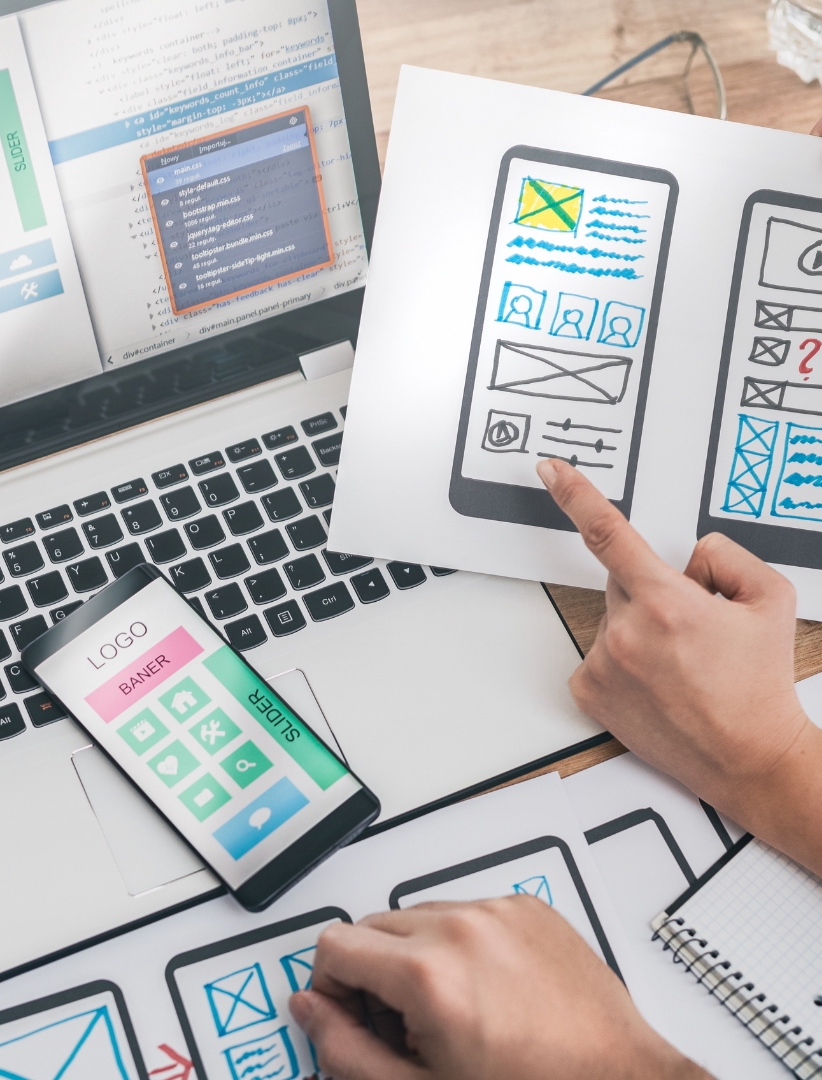 two-hands-laptop-phone-and-illustration-drawing-make-a-wireframe-of-hotel-website-redesign