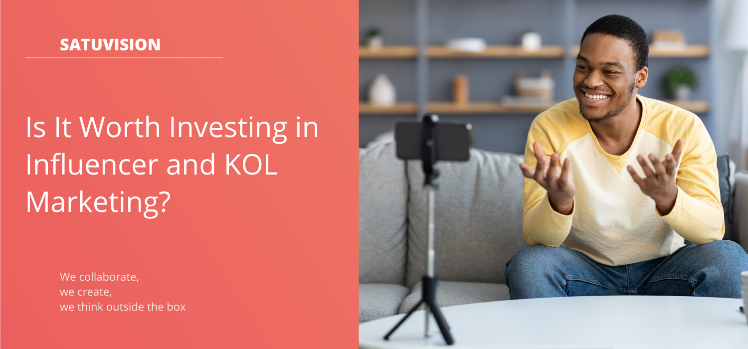 A man in a yellow long-sleeve shirt makes influencer and KOL marketing content for a hotel using a black phone and a black tripod.